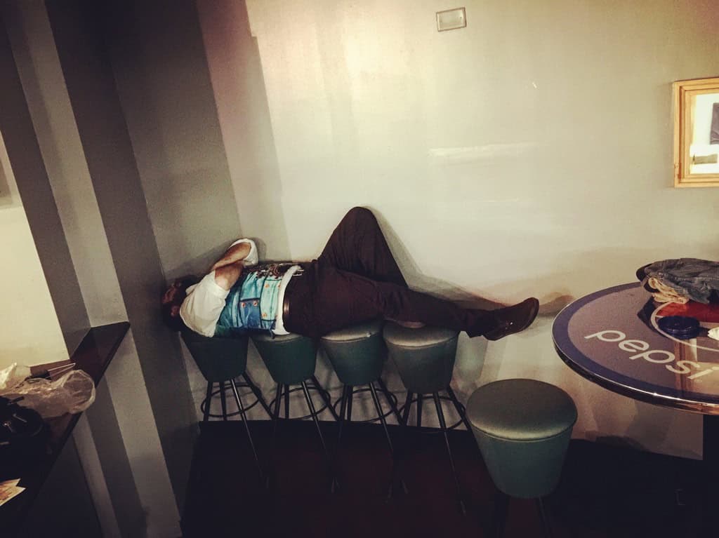Chaz Chambers sleeping across bar stools between Ringling Bros. performances during a nine-pack weekend in Richmond, Virginia